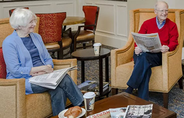 two seniors reading newspapers in our senior living community in Baltimore