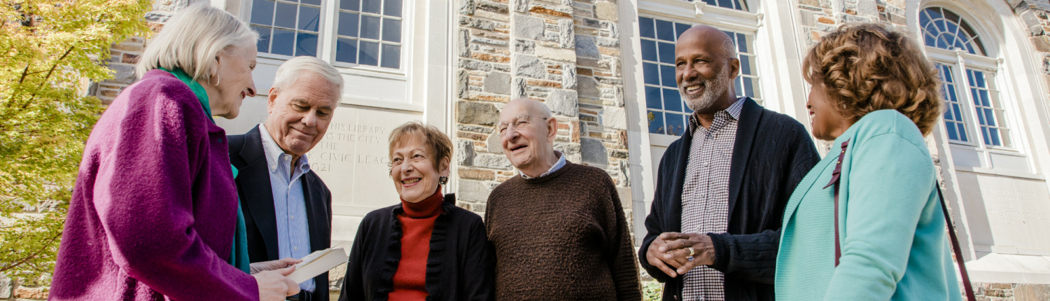 three Baltimore senior living residents talking in a group and standing outside the library 