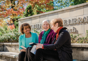 three senior women sitting outside Baltimore’s Enoch Pratt Free Library