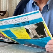 senior reading the Roland Park Place newsletter