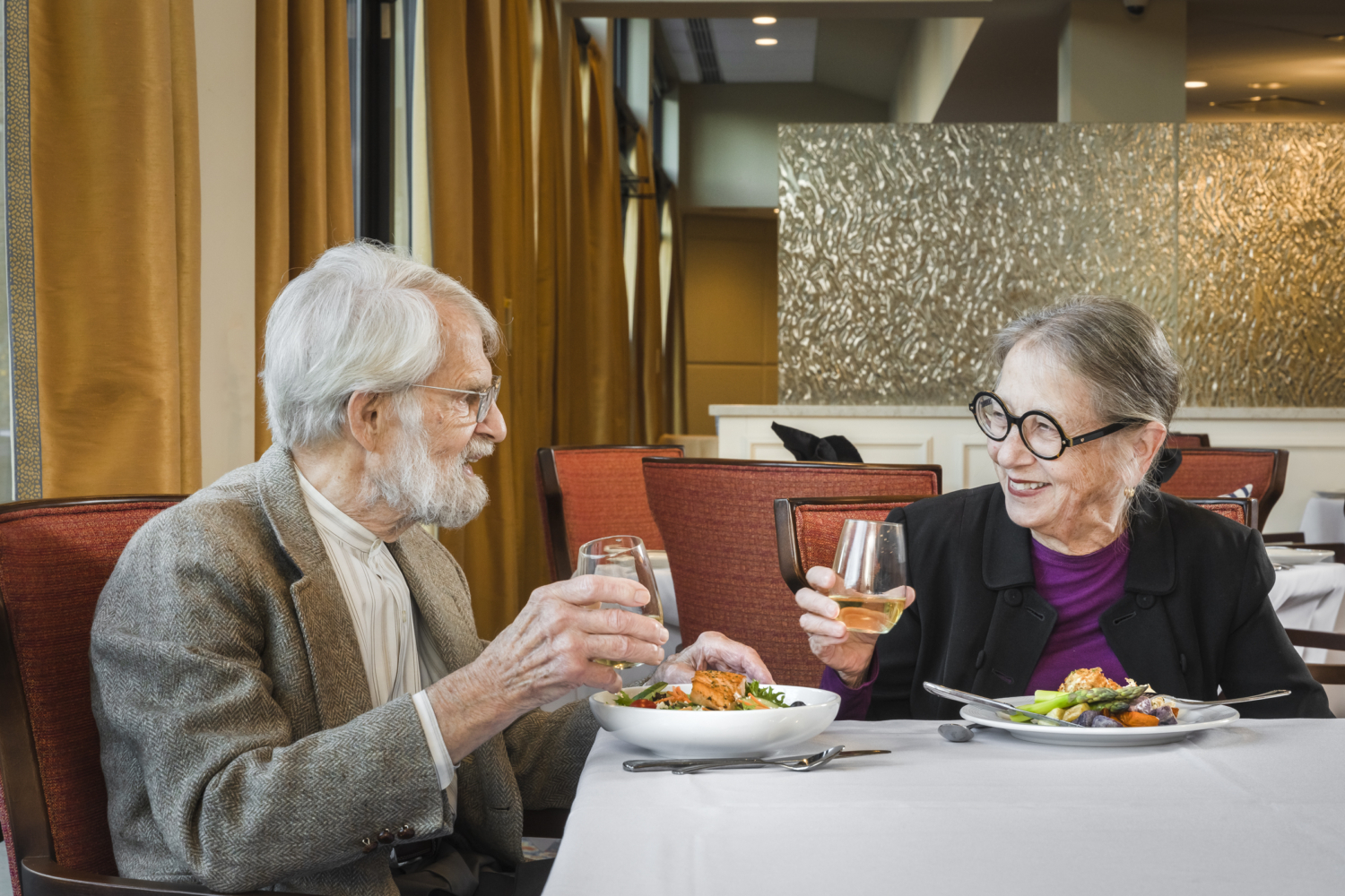 a senior man and woman having dinner together at a restaurant and talking