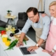 Image of a senior couple looking up a recipe on a laptop while preparing a healthy dinner. 