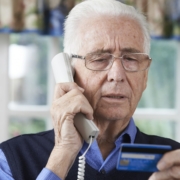 Senior man giving credit card details over the phone.