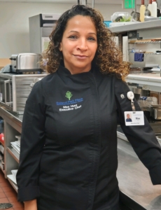Photo of Mae Hunt, the executive chef at Roland Park Place, standing in our senior living community's commercial kitchen